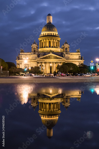 St. Isaac's Cathedral in the reflection of puddles at night in St. Petersburg