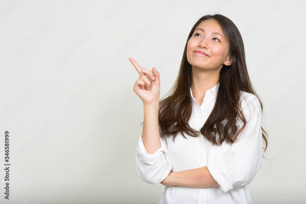 Portrait of young beautiful Asian businesswoman thinking Portrait of young beautiful Asian businesswoman thinking