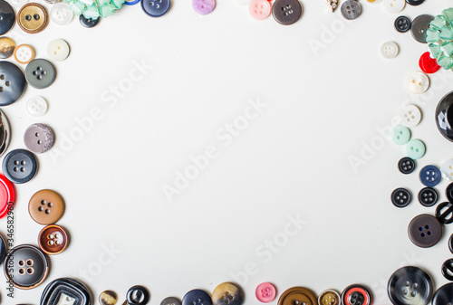 Threads and buttons of different colors on a white background.