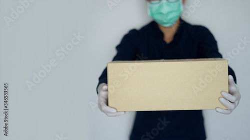 Business delivery man or postman holding item paper package box. Shipping and giving customer order to home
 photo