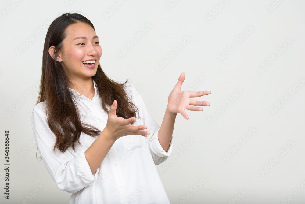 Portrait of happy young Asian businesswoman gesturing hands