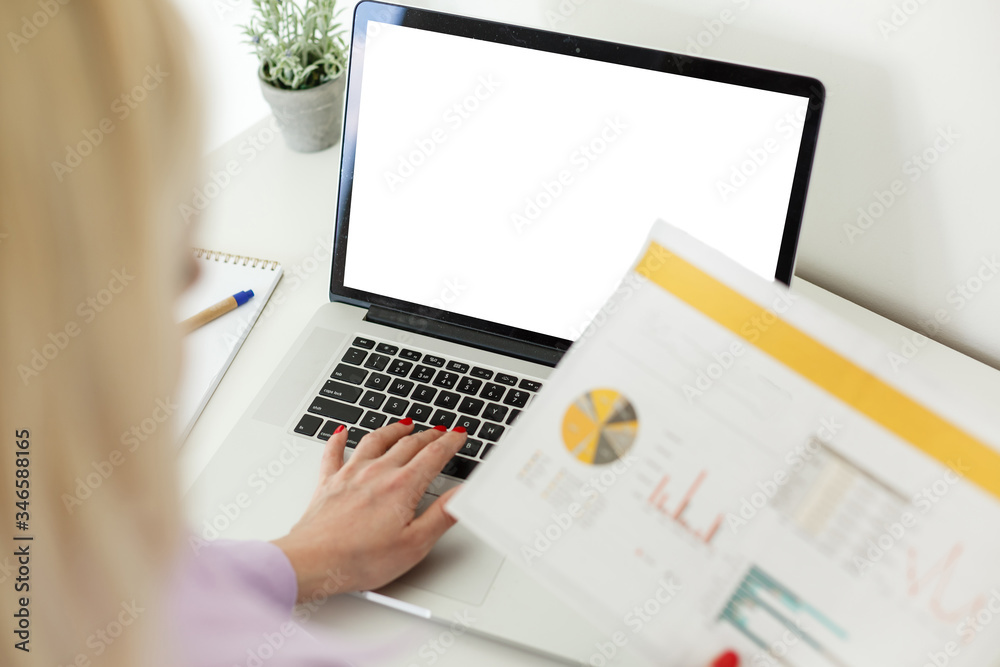 Rear view of business woman hands busy using laptop blank screen at office desk, with copyspace Rear view of business woman hands busy using laptop blank screen at office desk, with copyspace