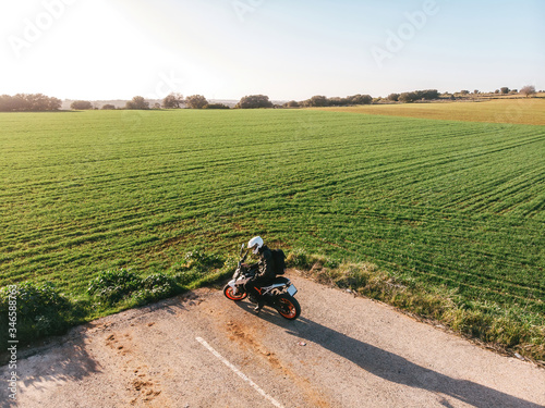 Biker on a motorcycle with view of green fields
