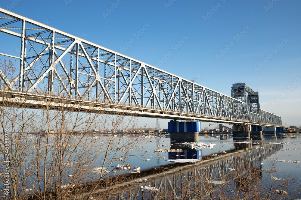 Fototapeta premium Spring evening in Arkhangelsk. Ice drift on the Severnaya Dvina river. The world's northernmost drawbridge.
