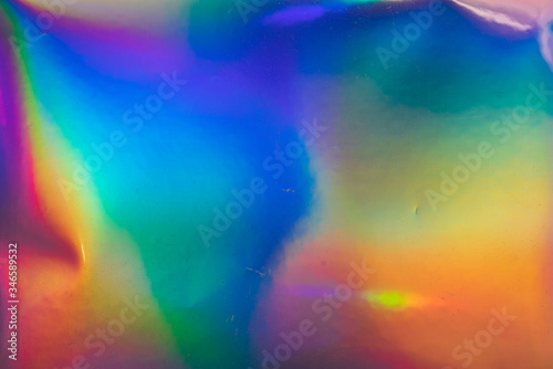 high res macro photo of abstract pastel iridescent holographic foil background with light leaks. holo color wrinkled material. cool glitter surface with shiny rainbow neon feel.