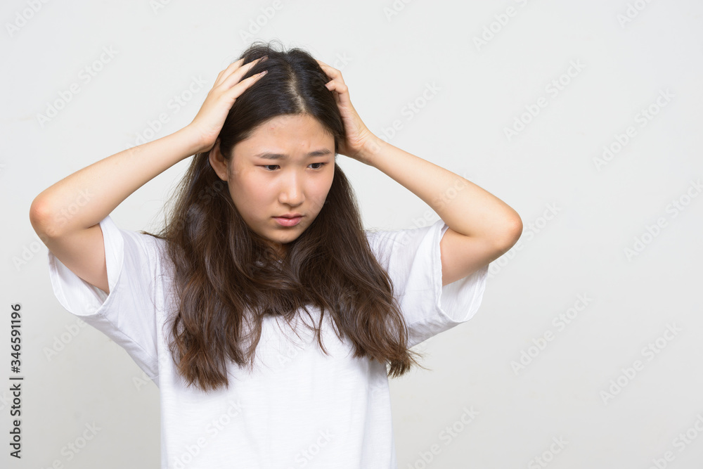 Portrait of stressed young Asian woman having headache