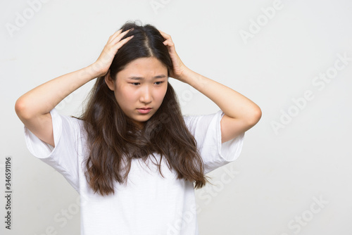 Portrait of stressed young Asian woman having headache