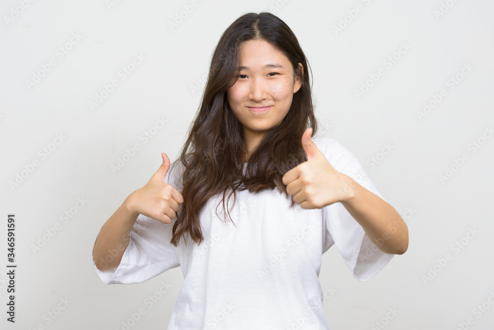 Portrait of young beautiful Asian woman giving thumbs up Portrait of young beautiful Asian woman giving thumbs up