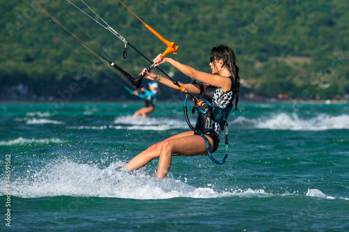 Beautiful girl with black hair kiting in the clear waters of the Indian Ocean. Mauritius