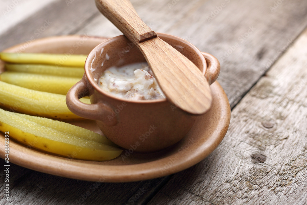 Lard and pickled cucumber.
Appetizing dish on a wooden table. Lard and pickled cucumber.
Appetizing dish on a wooden table.