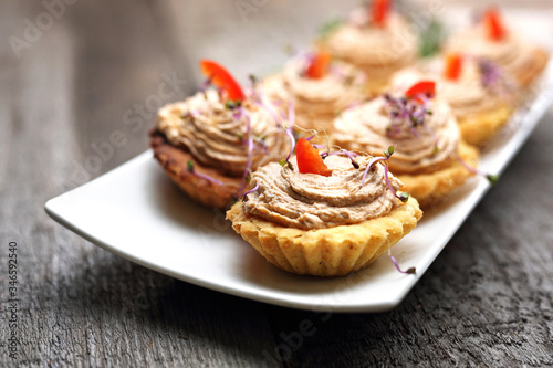 Dry muffins stuffed with liver mousse.
Appetizing dish on a wooden table.
