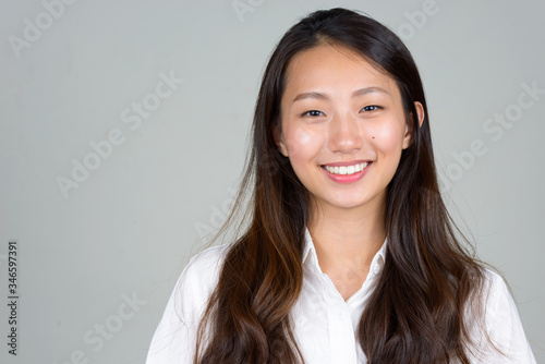 Face of happy young beautiful Asian businesswoman smiling photo