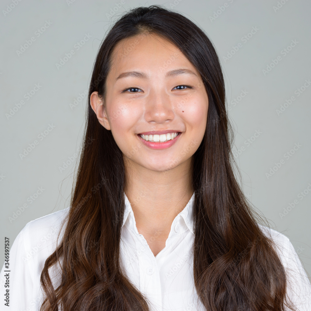 Face of happy young beautiful Asian businesswoman smiling Face of happy young beautiful Asian businesswoman smiling