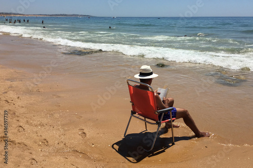 hombre leyendo en la playa