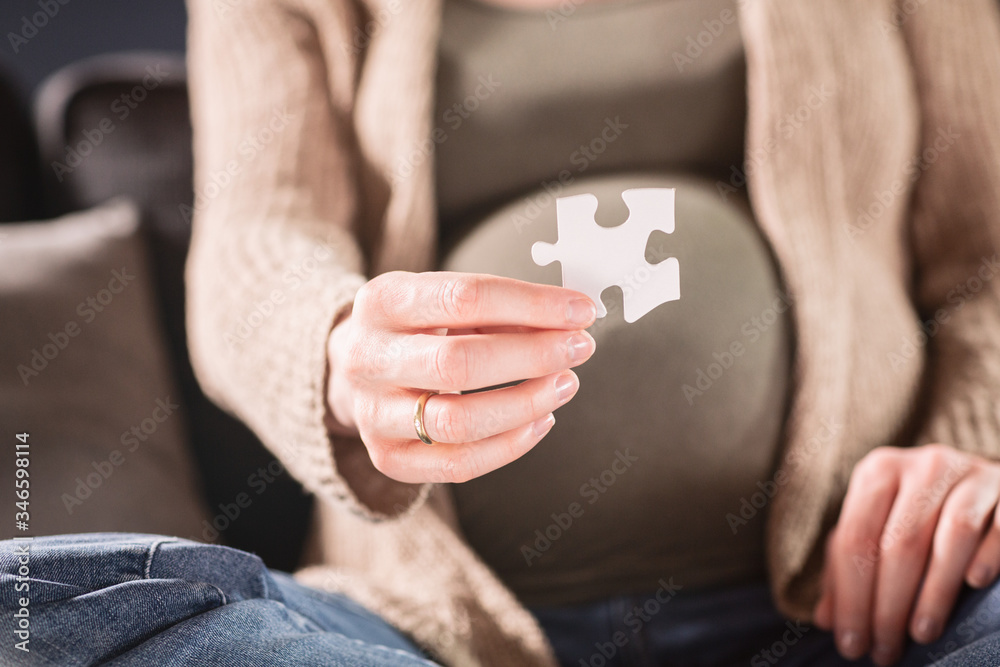 Pregnant Woman Holding a Piece of a Puzzle Before Her Belly Pregnant Woman Holding a Piece of a Puzzle Before Her Belly