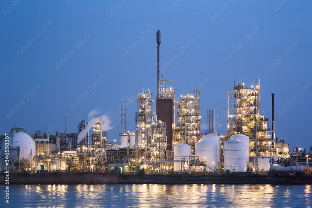 Chemical Plant or Factory Along a River with Lights On
