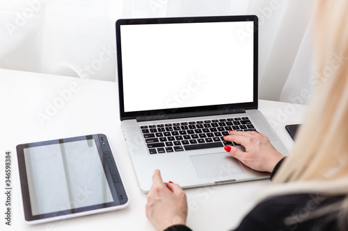 Female person sitting front open laptop computer with blank empty screen for your information or content while talking on smart phone, businesswoman work on notebook at breakfast in modern coffee shop