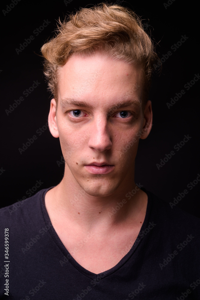 Face of young blond Scandinavian man against black background Face of young blond Scandinavian man against black background