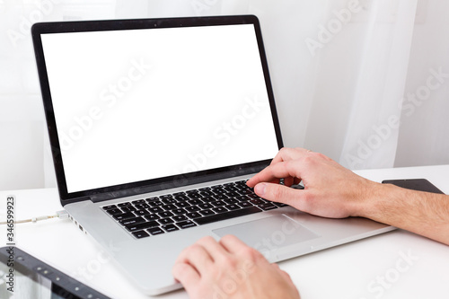 Back view of male person sitting front open laptop computer with blank empty screen for your information or content, modern businessman working in internet