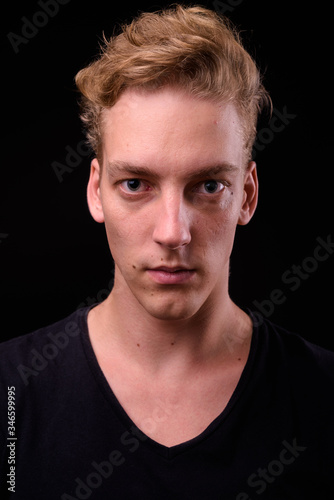 Face of young blond Scandinavian man against black background © Ranta Images