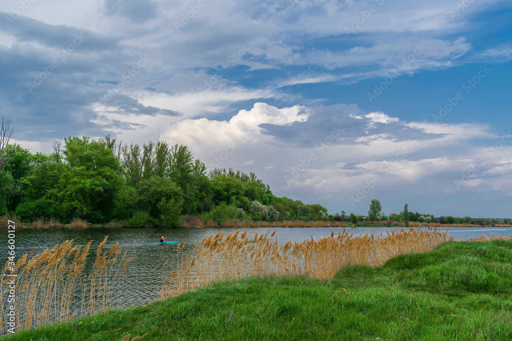 Osnny landscape in the Zhuravlevsky Hydropark of Kharkov with a view of the river and a man in a kayak