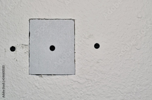 Drywall repairs in wall with a square repair panel screwed in for support. Copy space on the right side of image. Repair, DIY home maintenance, step by step.