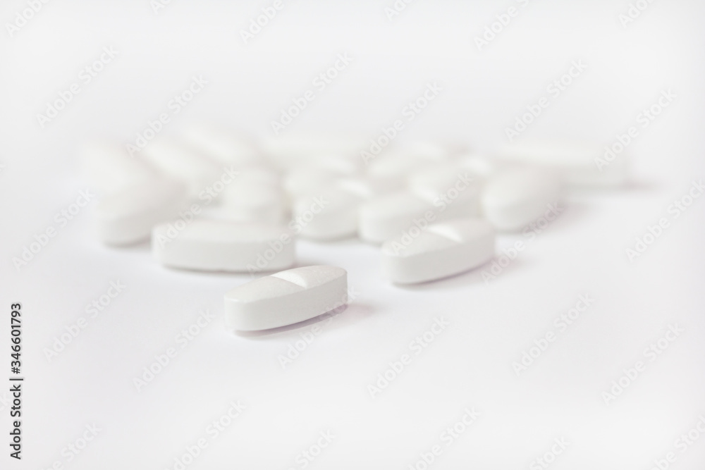 White pills on a white background close-up. Painkillers. A remedy for the Covid19 virus. Tablet macro. Copy space. White pills on a white background close-up. Painkillers. A remedy for the Covid19 virus. Tablet macro. Copy space.