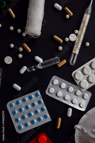 Flat doctor's table with pills, thermometer, ampoules, syringe. Vertical photo. Medicine concept.