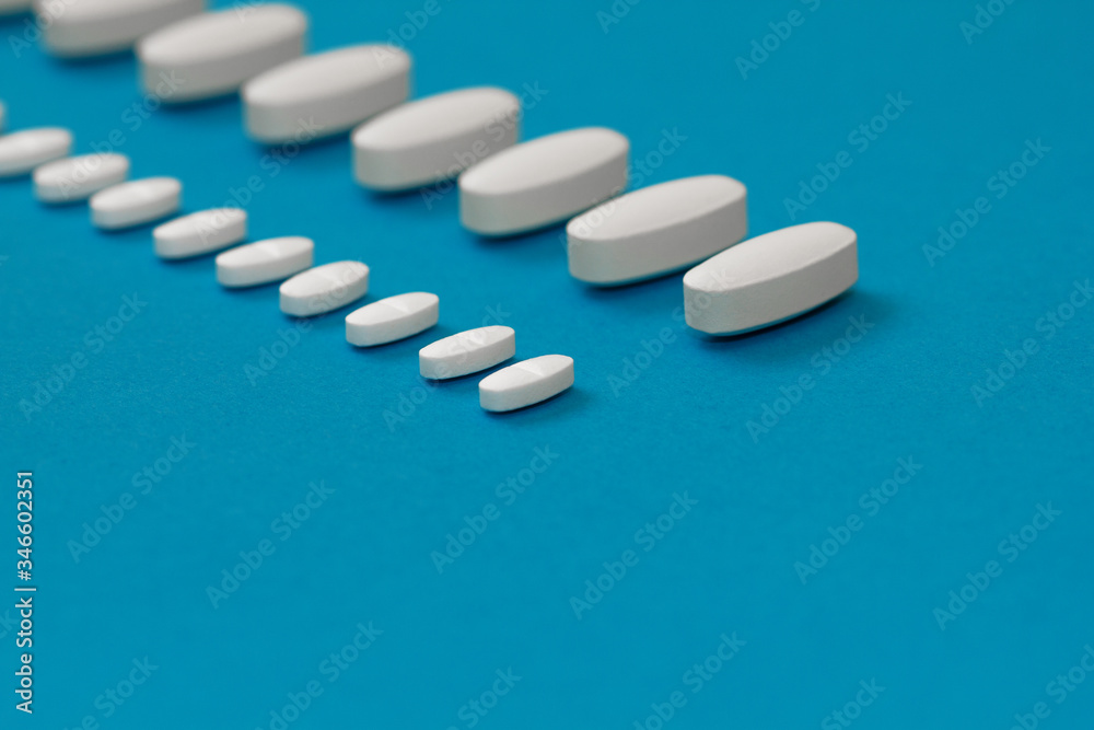 White tablets on a blue background close-up. Macro pills. Medical care for flu and colds. Protection from Covid19 White tablets on a blue background close-up. Macro pills. Medical care for flu and colds. Protection from Covid19