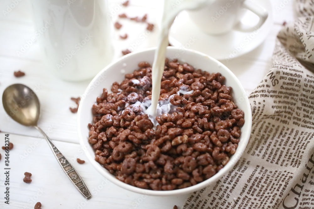 Fototapeta premium Milk is poured into chocolate balls. Breakfast cereal