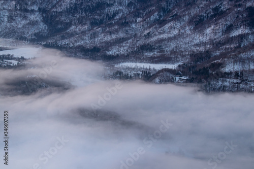 Clouds covering snowy hills  Bohinj