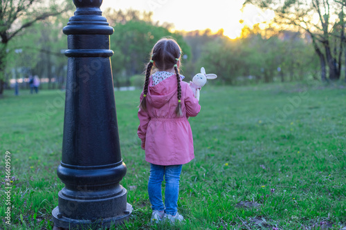 little girl outdoors alone with a toy, without parents, social