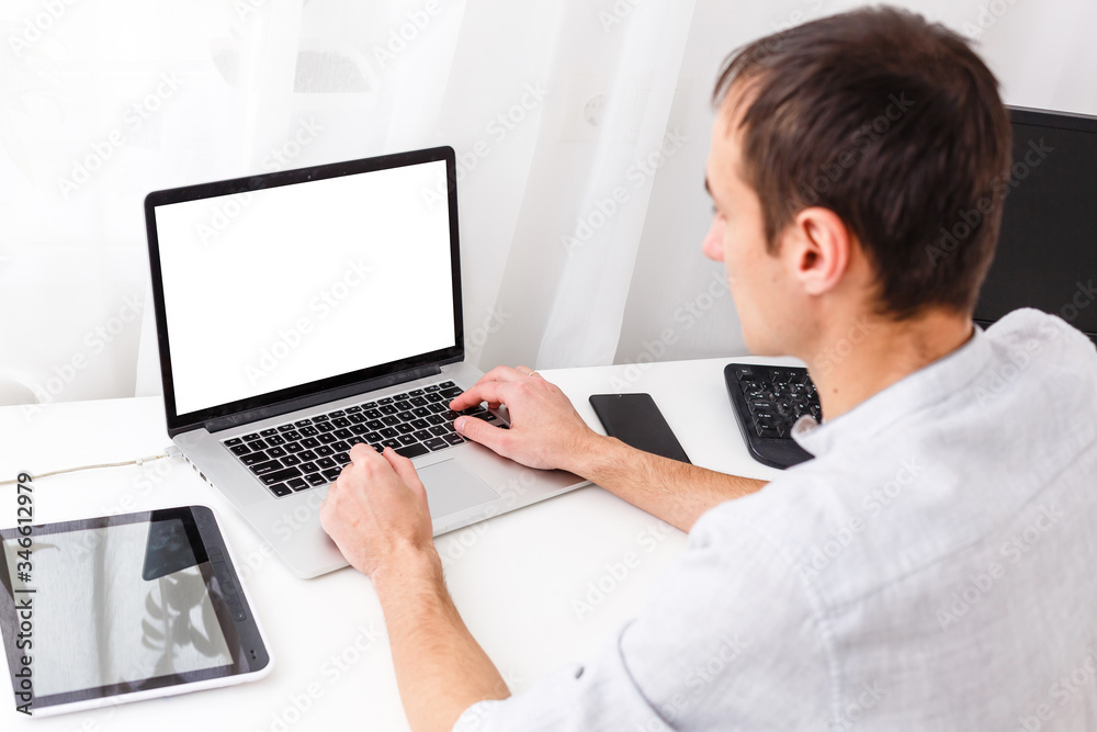 Back view of male person sitting front open laptop computer with blank empty screen for your information or content, modern businessman working in internet Back view of male person sitting front open laptop computer with blank empty screen for your information or content, modern businessman working in internet