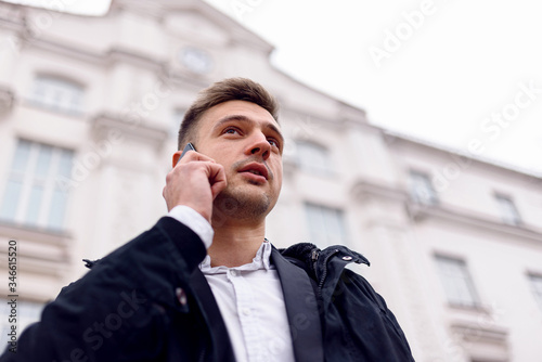Smiling young man talking on his phone outdoors