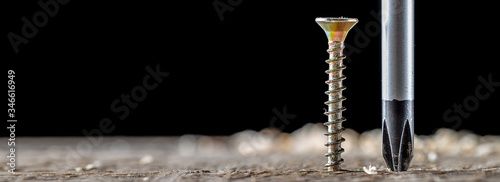 Fotografie The screw and screwdriver close up on black background