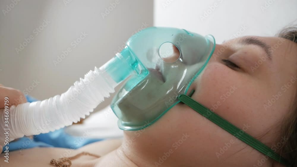 A patient wearing an oxygen mask has problems with a respiratory illness.A patient with an oxygen mask in a hospital with a pandemic of the coronavirus Covid19