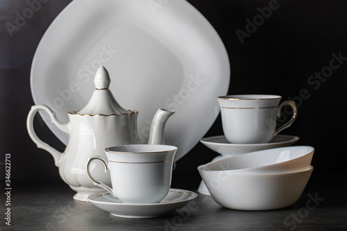 White porcelain tea set-folded cups and saucers and teapot.