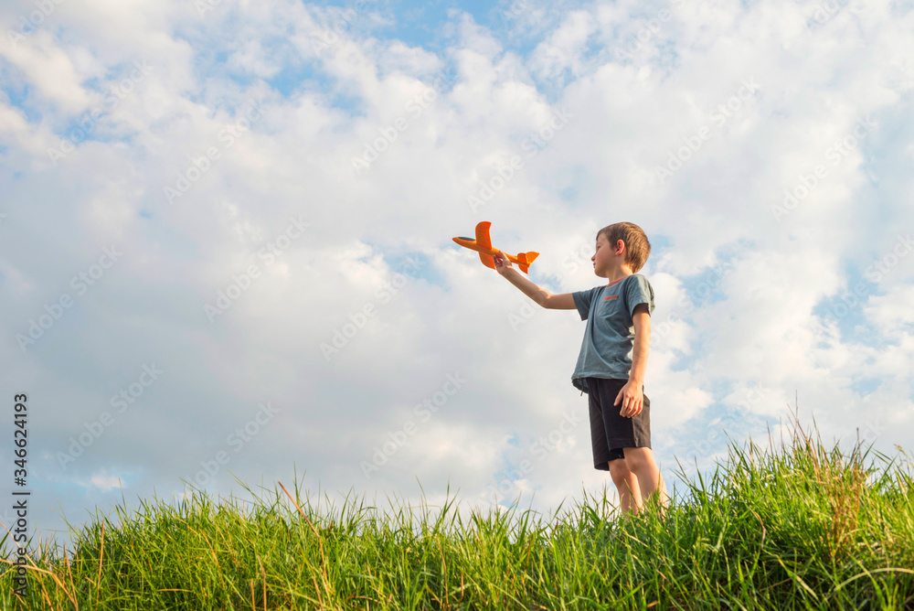 Little boy launches a toy plane into the air. Child launches a toy plane Little boy launches a toy plane into the air. Child launches a toy plane