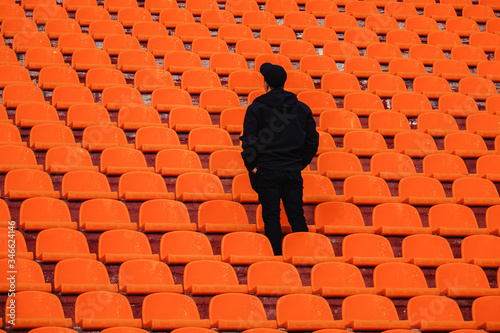 the guy in black stands alone in the orange stands