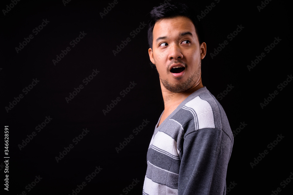 Obraz premium Rear view of shocked young Asian man looking back