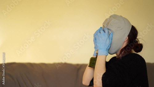 white woman in medical gloves puts on a gas mask