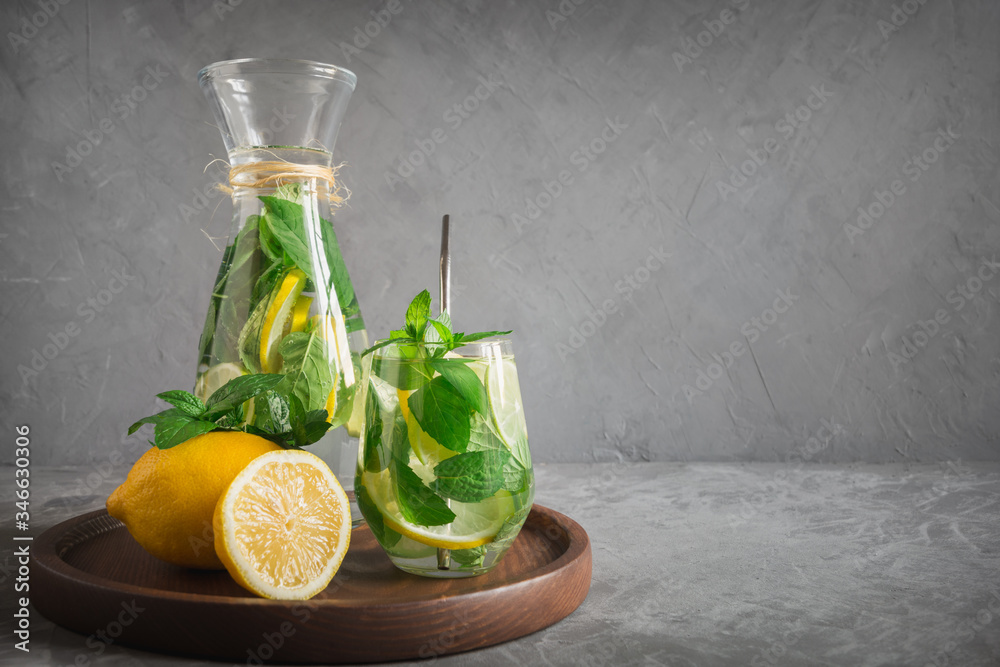 Detox water or lemonade with lemon mint, citrics in glass on grey background. Close up. Horizontal shot. Space for text. Detox water or lemonade with lemon mint, citrics in glass on grey background. Close up. Horizontal shot. Space for text.