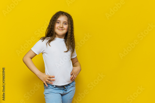 Beautiful little fashion model on Yellow studio background.