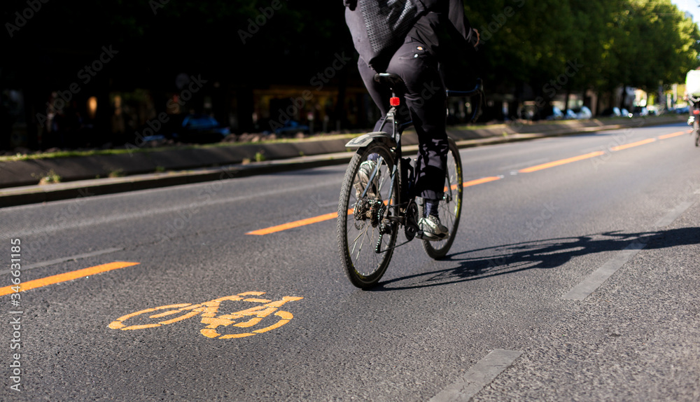 Breite Fahrradspur in der Stadt. Fahrrad Zeichen auf Straße. Ökologischer urbaner Verkehr. Wide bicycle lane in city. Cycle lane with orange painted bike on asphalt.