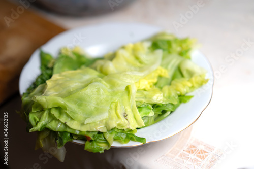 Boiled cabbage leaves lie in a plate