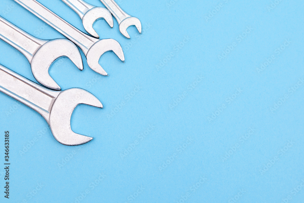Tools worker, many wrenchs on a blue background, top view with free space Tools worker, many wrenchs on a blue background, top view with free space