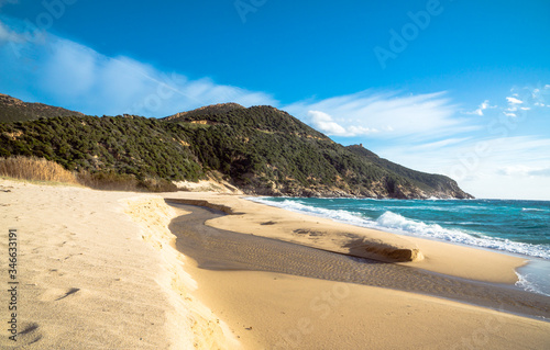 River flows through sand to the sea at Solanas Beach in Sardinia Italy