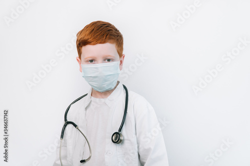 Close up of caucasian littile doctor with a stethoscope in protective mask