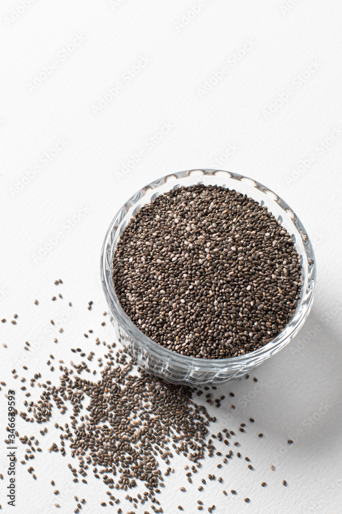 Chia seeds in a cup beautifully laid out on a white background. copy space. Vegetarian food. Chia seeds in a cup beautifully laid out on a white background. copy space. Vegetarian food.
