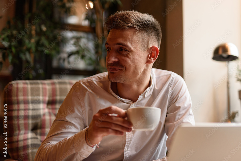 Happy young man holding cup in cafe Happy young man holding cup in cafe